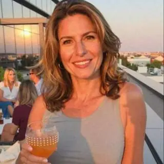 Femme souriante en terrasse pour illustrer une rencontre adulte